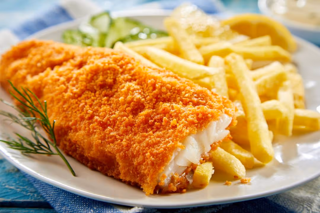 Plate with crispy breaded fried fish, French fries, cucumber slices, and a lemon wedge.