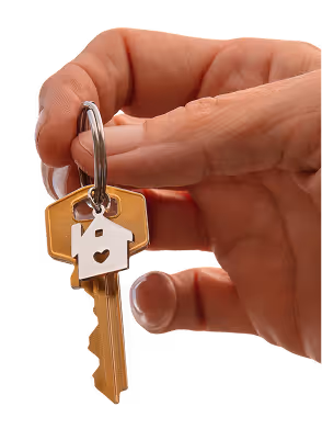 Hand holding a key with a house-shaped keychain featuring a heart cutout.
