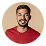 Smiling man with short hair and beard wearing a red shirt against a white background.