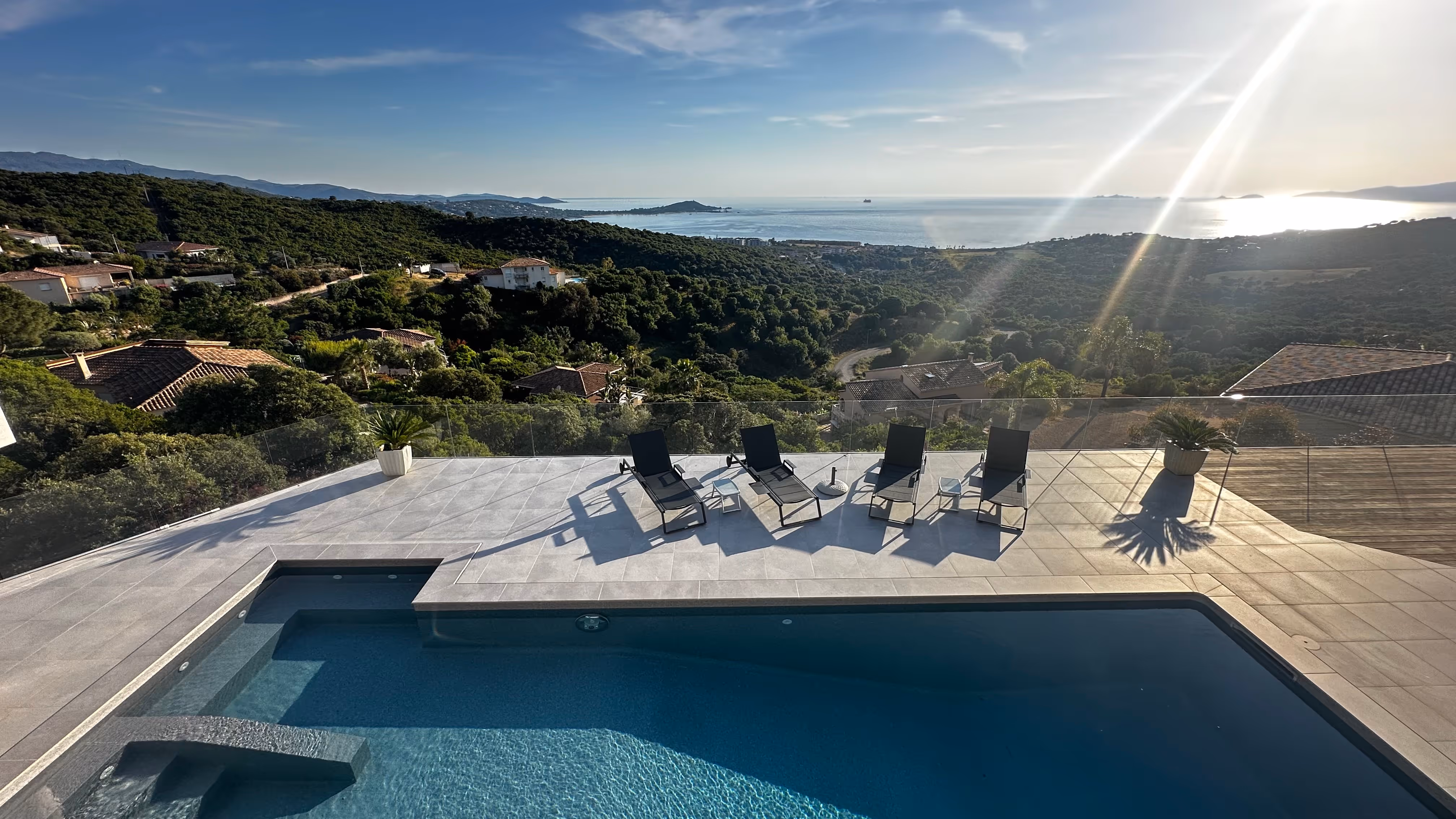 Terrasse étage Villa Lola, transats vue sur piscine, maquis et golfe d'Ajaccio avec plage d'Isolella