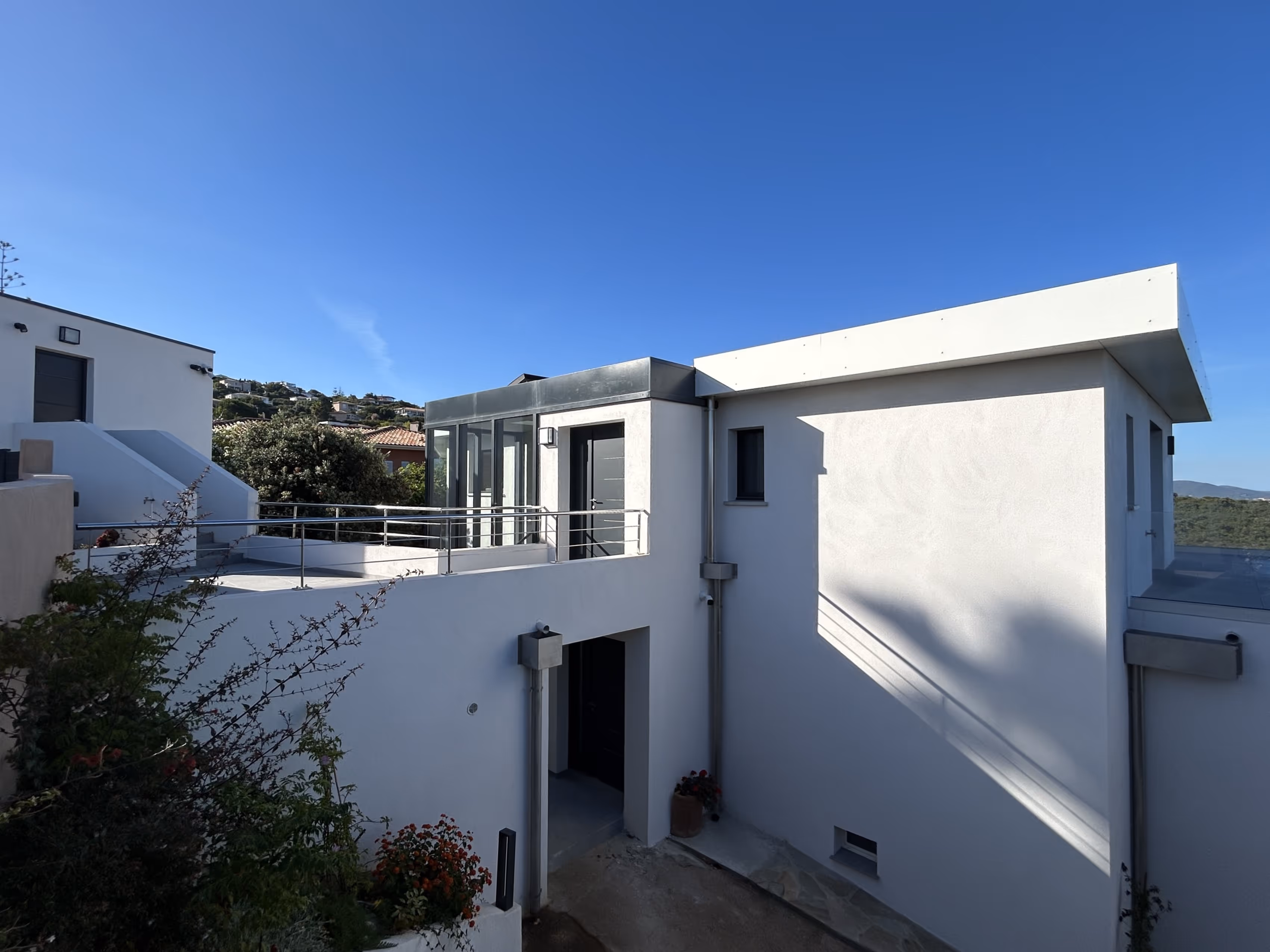 Salon Villa Lola ouvert sur cuisine, grande hauteur sous plafond, vue panoramique piscine et îles Sanguinaires