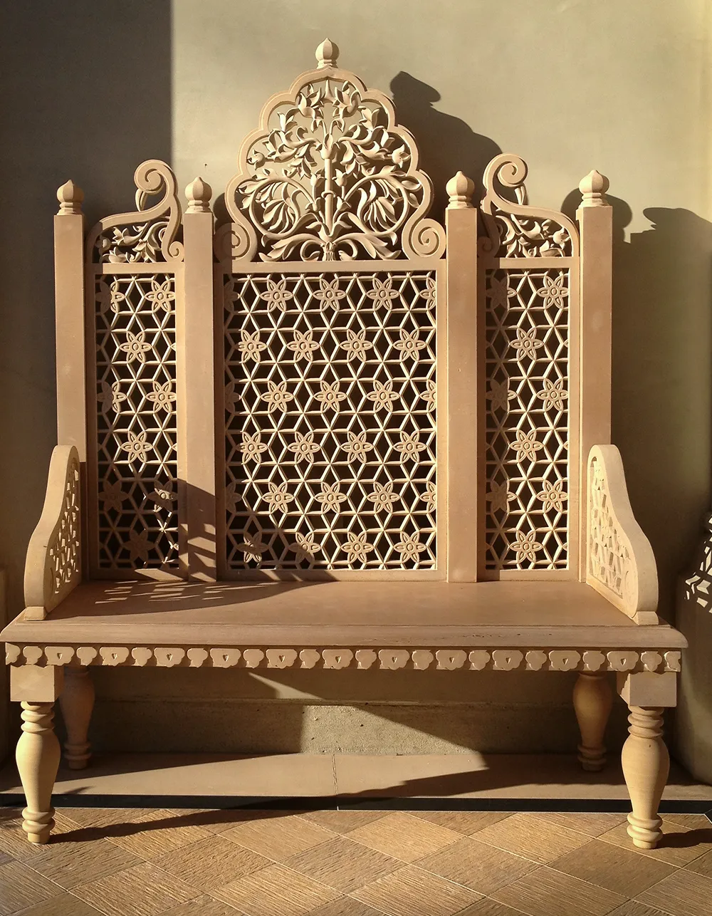 Hand-carved sandstone bench with a jali lattice back and floral crest