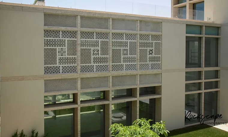 Hand-carved stone jali screen panels on a building facade