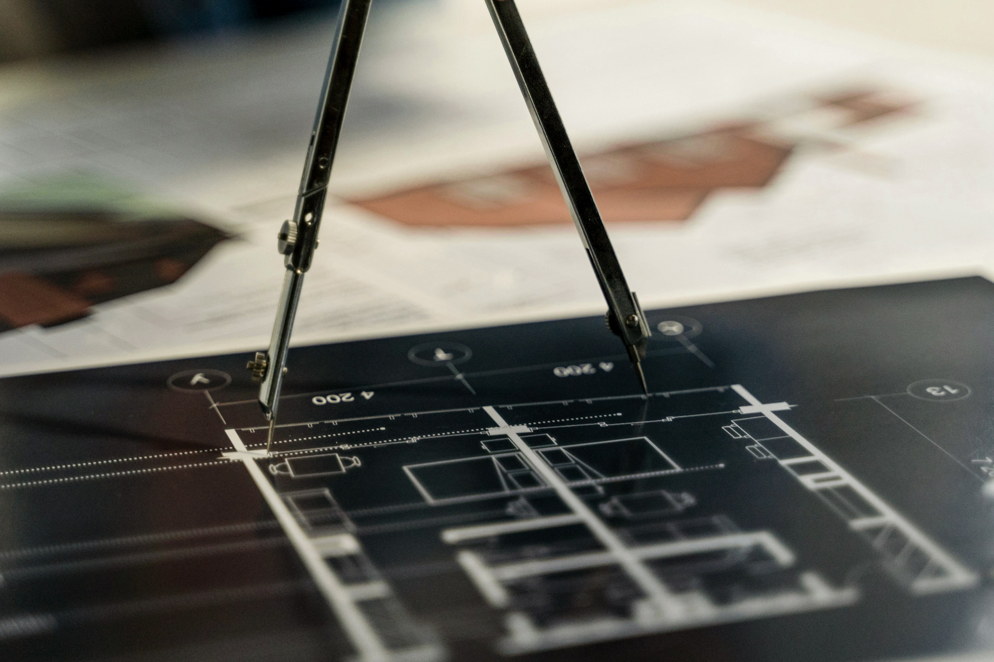 Hand zeichnet auf einem Architekturplan mit dreidimensionalen Miniaturbäumen und bepflanzten Flächen