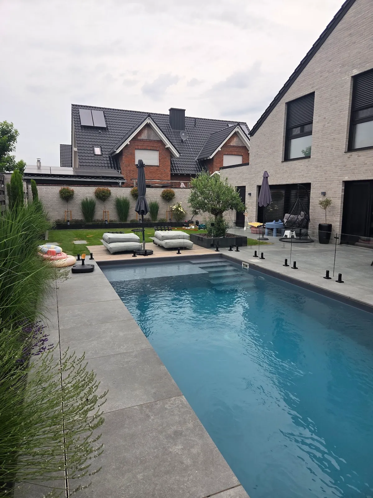Glaswand als Windschutz am Pool im Garten