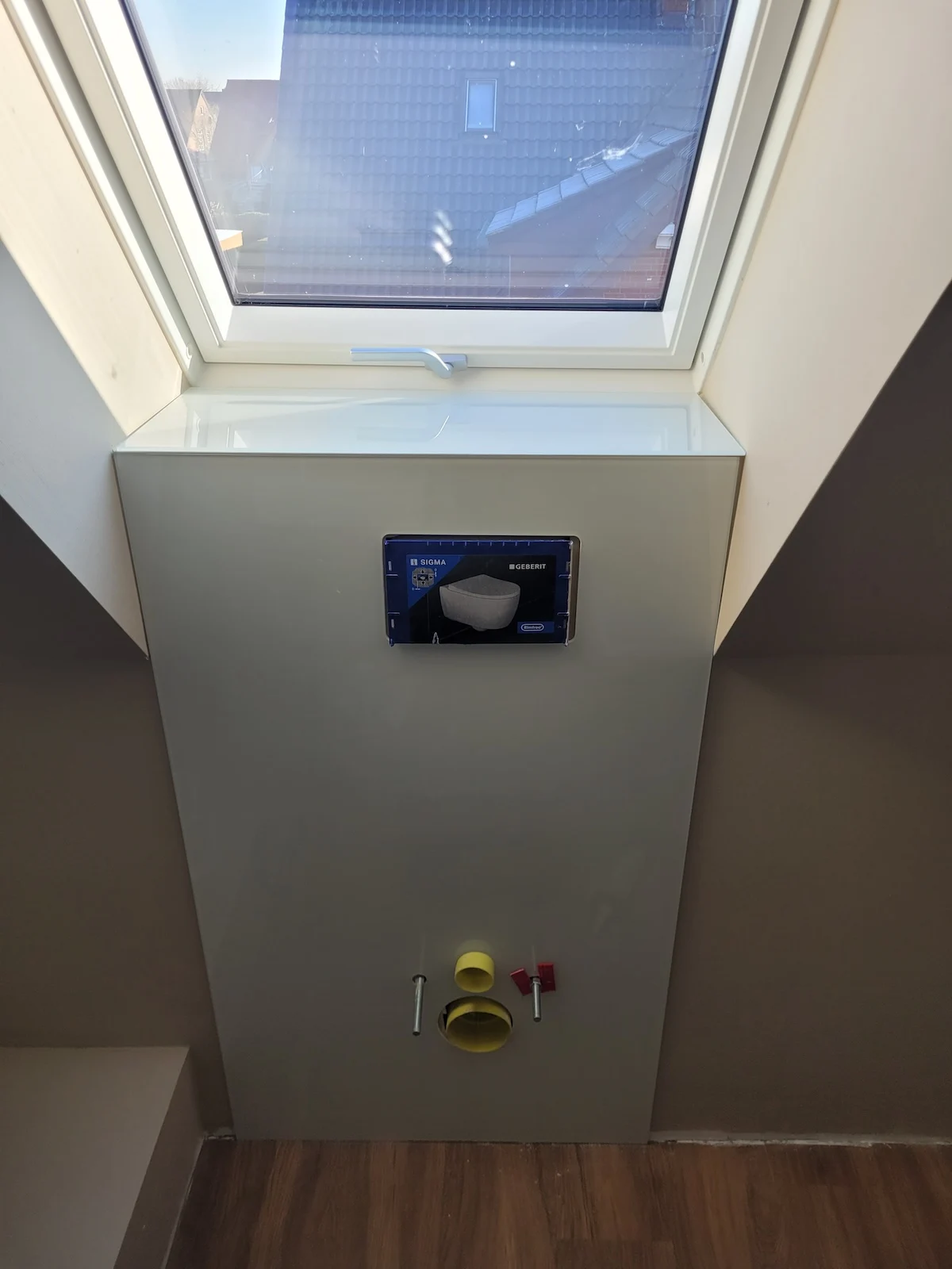 Glas-Vorwandverkleidung an einem WC-Spülkasten unter Dachfenster
