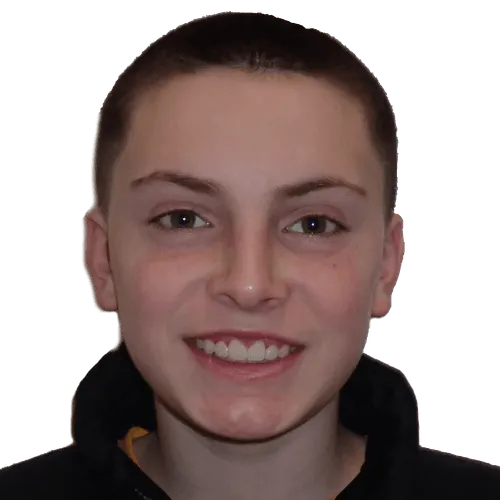 Close-up of a young person with short hair smiling at the camera wearing a dark jacket.