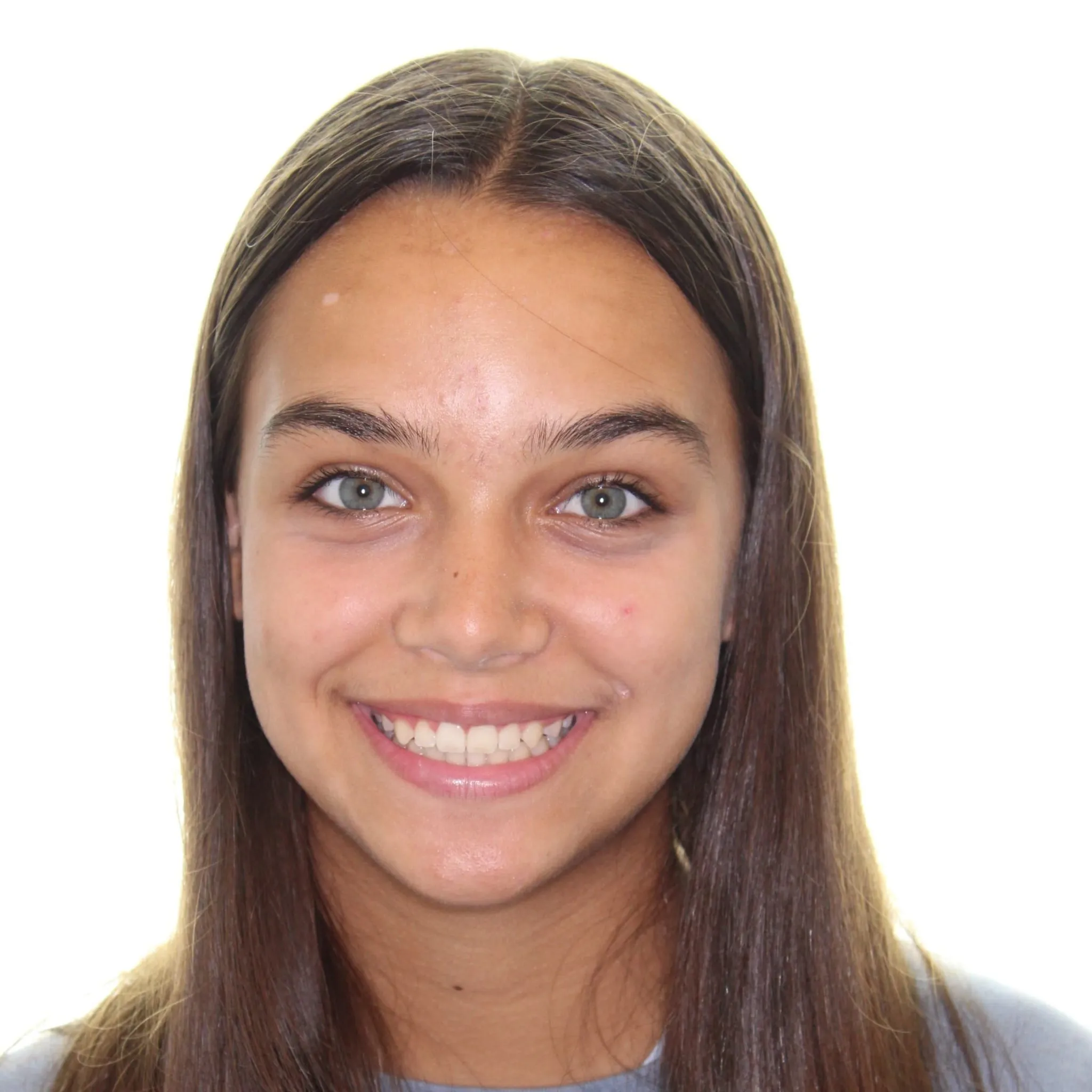 Smiling young woman with long brown hair and gray eyes against a white background.