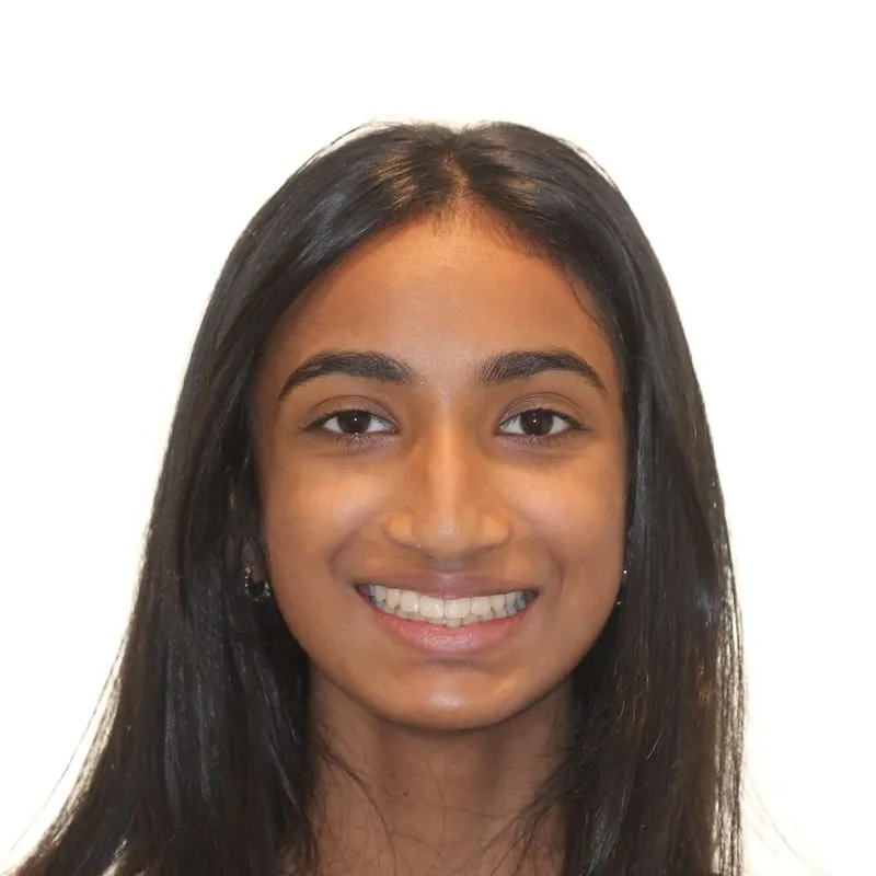 Smiling young woman with long dark hair and clear skin against a white background.
