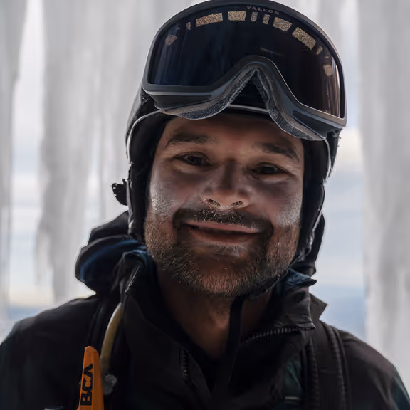 Stratton smiling in his ski helmet and goggles on a cold mountain day.
