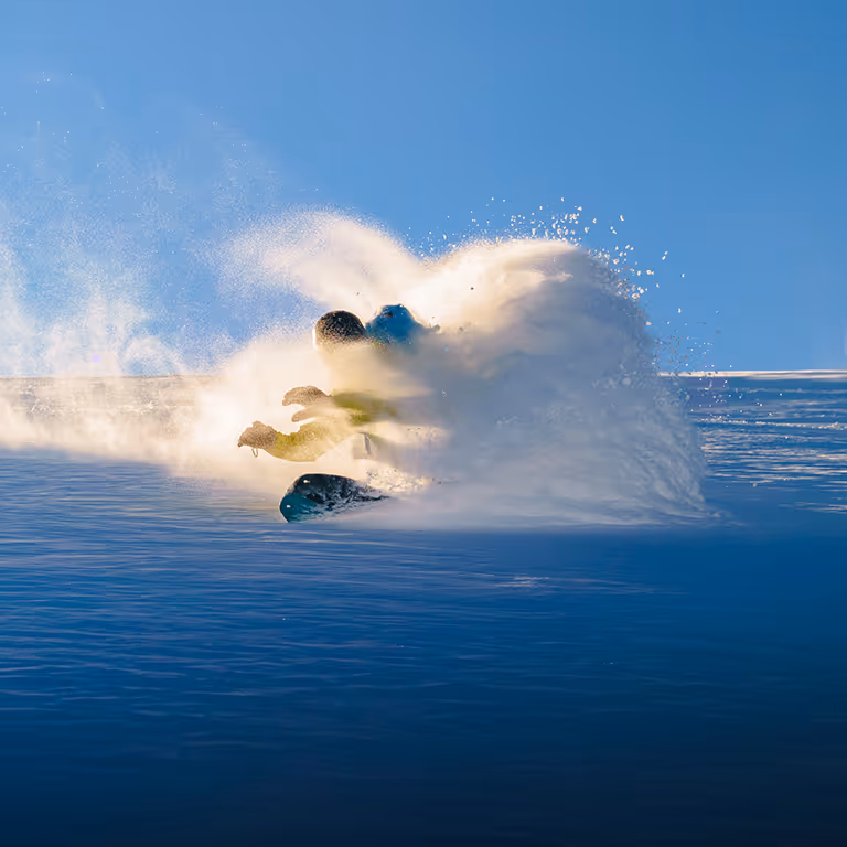 Stratton snowboarding through a massive powder explosion on a bluebird day.