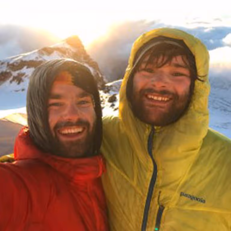 Stratton and his best friend Alex Kollar smiling together on a snowy mountain summit.