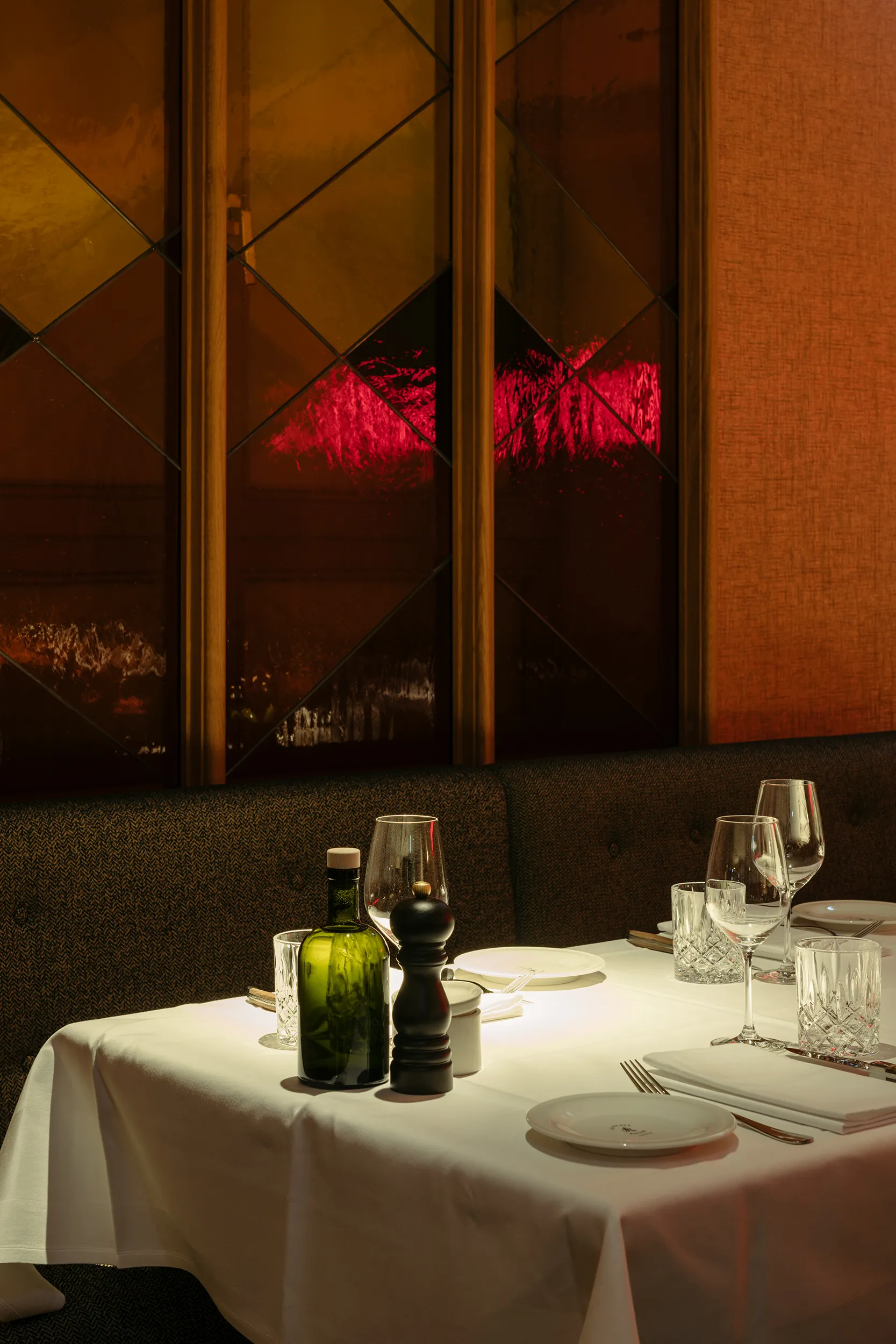 Abendlich gedeckter Tisch mit Kristallgläsern und diamantgemustertem Spiegel im Le Petit Royal Frankfurt