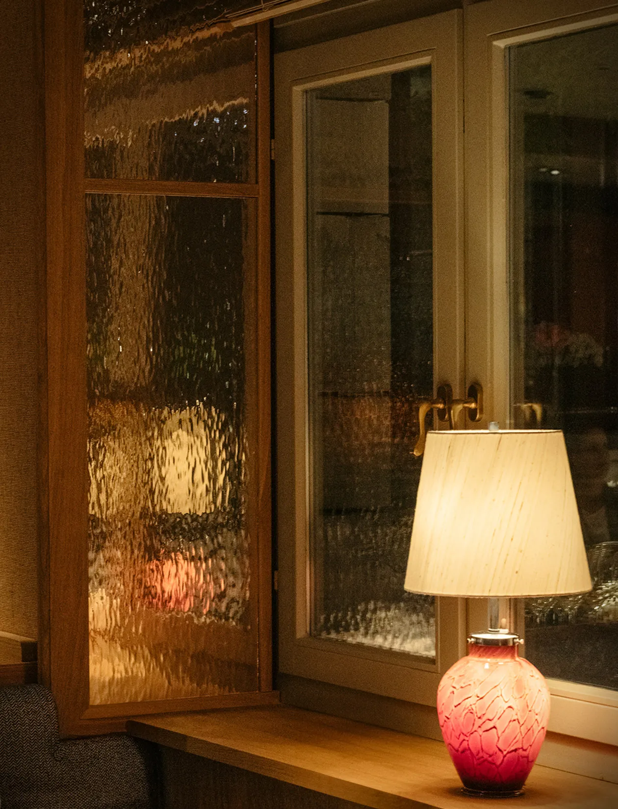 Stimmungsvolle Atmosphäre im Le Petit Royal Frankfurt – rote Glaslampe am Fenster bei Nacht