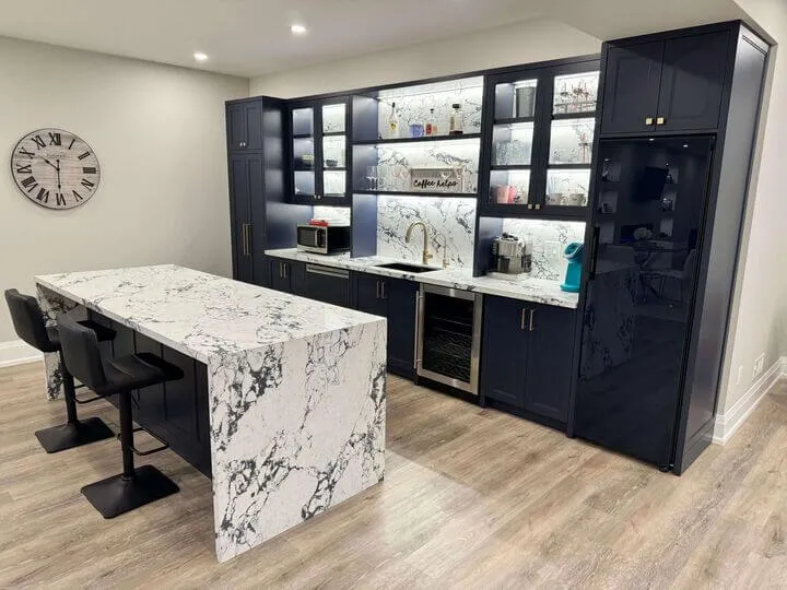 Basement Finishing showcaseing marble bar, dark blue countertop and light brown laminate flooring