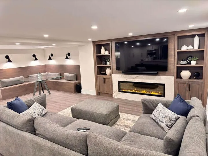 Basement family room with brown tv cabinetry and brown bench