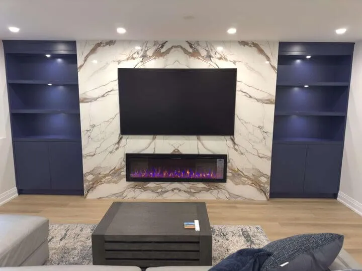 Basement media wall with navy built-ins and marble surround