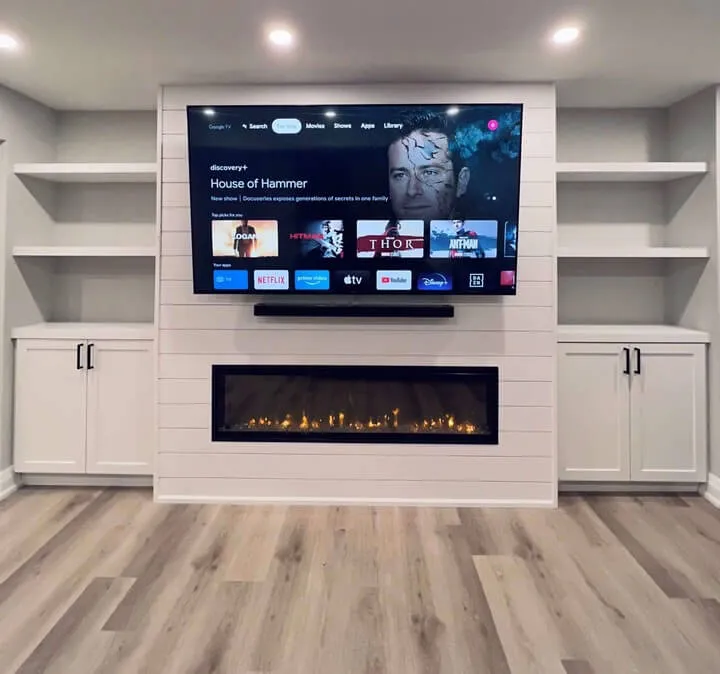 Basement TV wall with electric fireplace and white shiplap