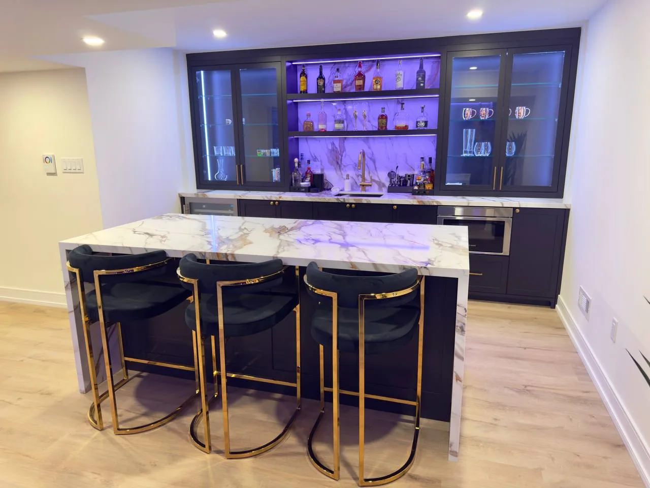 Home renovations in Vaughan — basement bar with marble waterfall island and LED shelves
