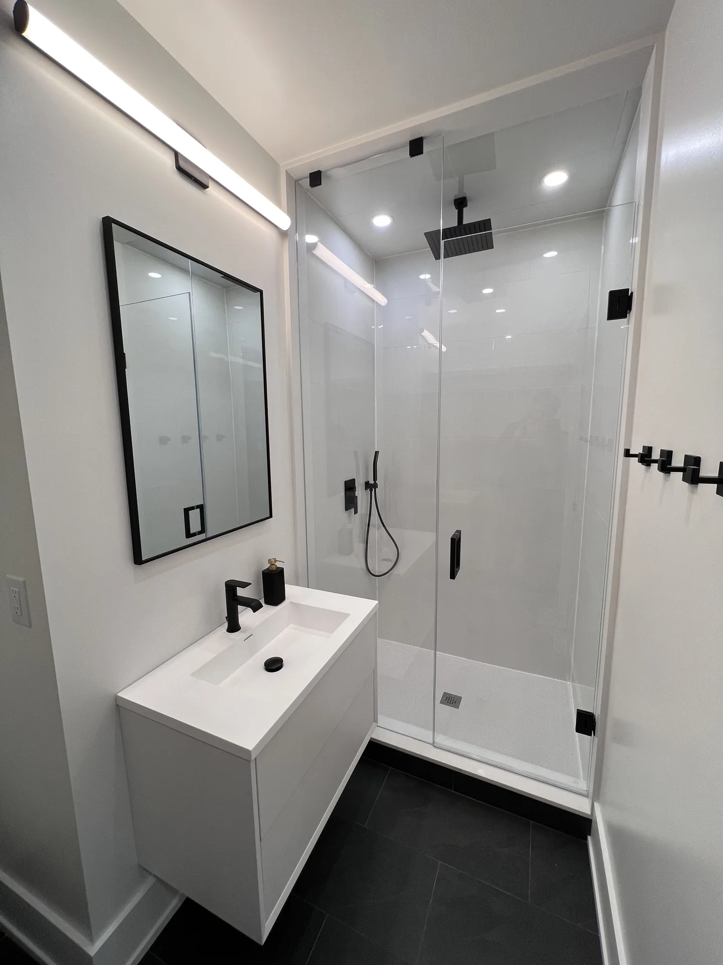 Structural work in North York — basement bathroom with walk-in glass shower and black fixtures