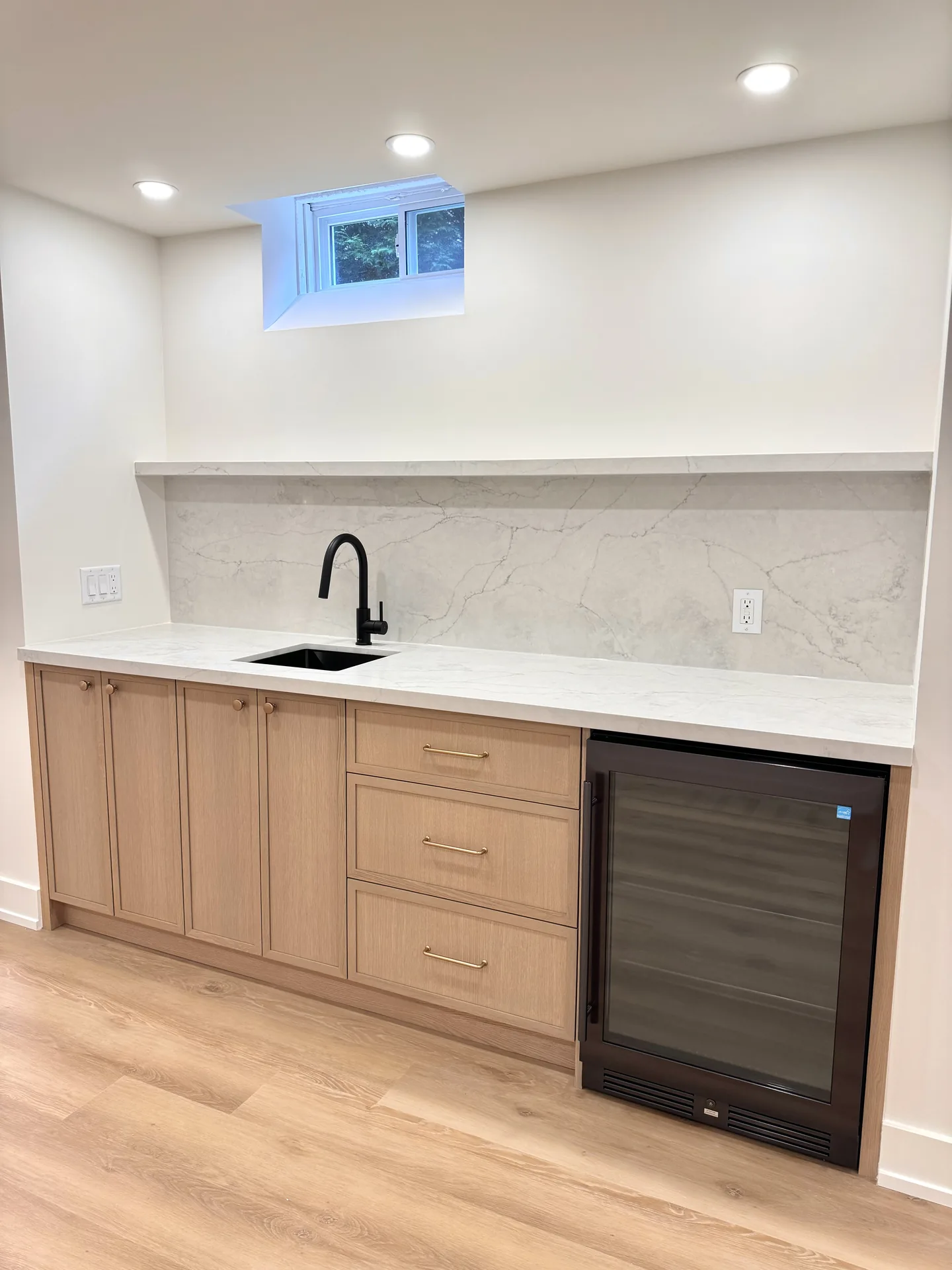 Home renovations in Kleinburg — beige basement wet bar with wine fridge and floating shelf