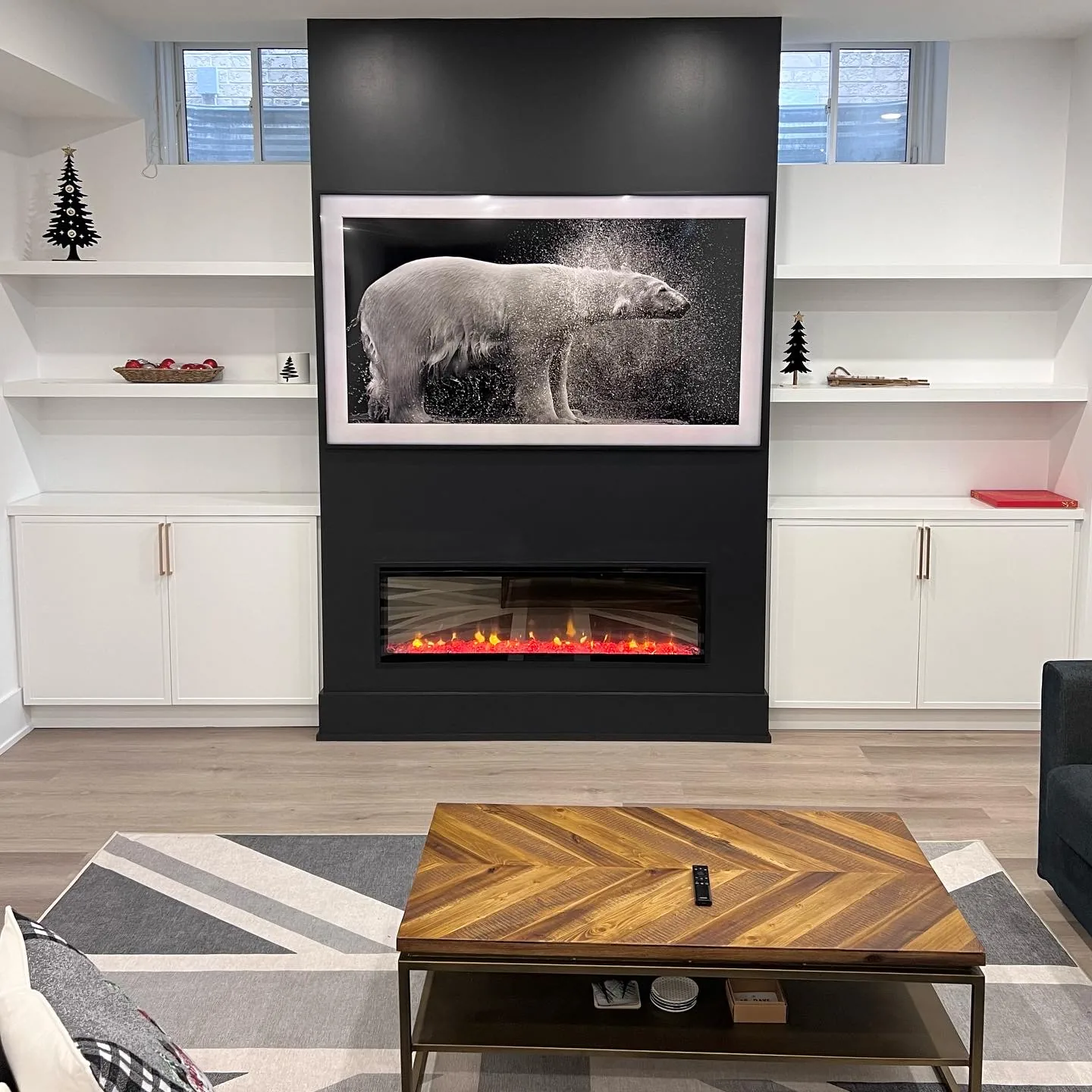 Basement finishing in North York — black and white basement media wall with electric fireplace and herringbone table