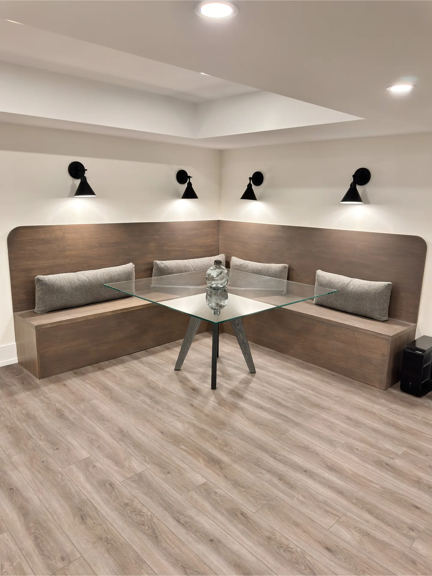 Home renovations in Markham — custom corner banquette bench with millwork and sconces in a finished GTA basement