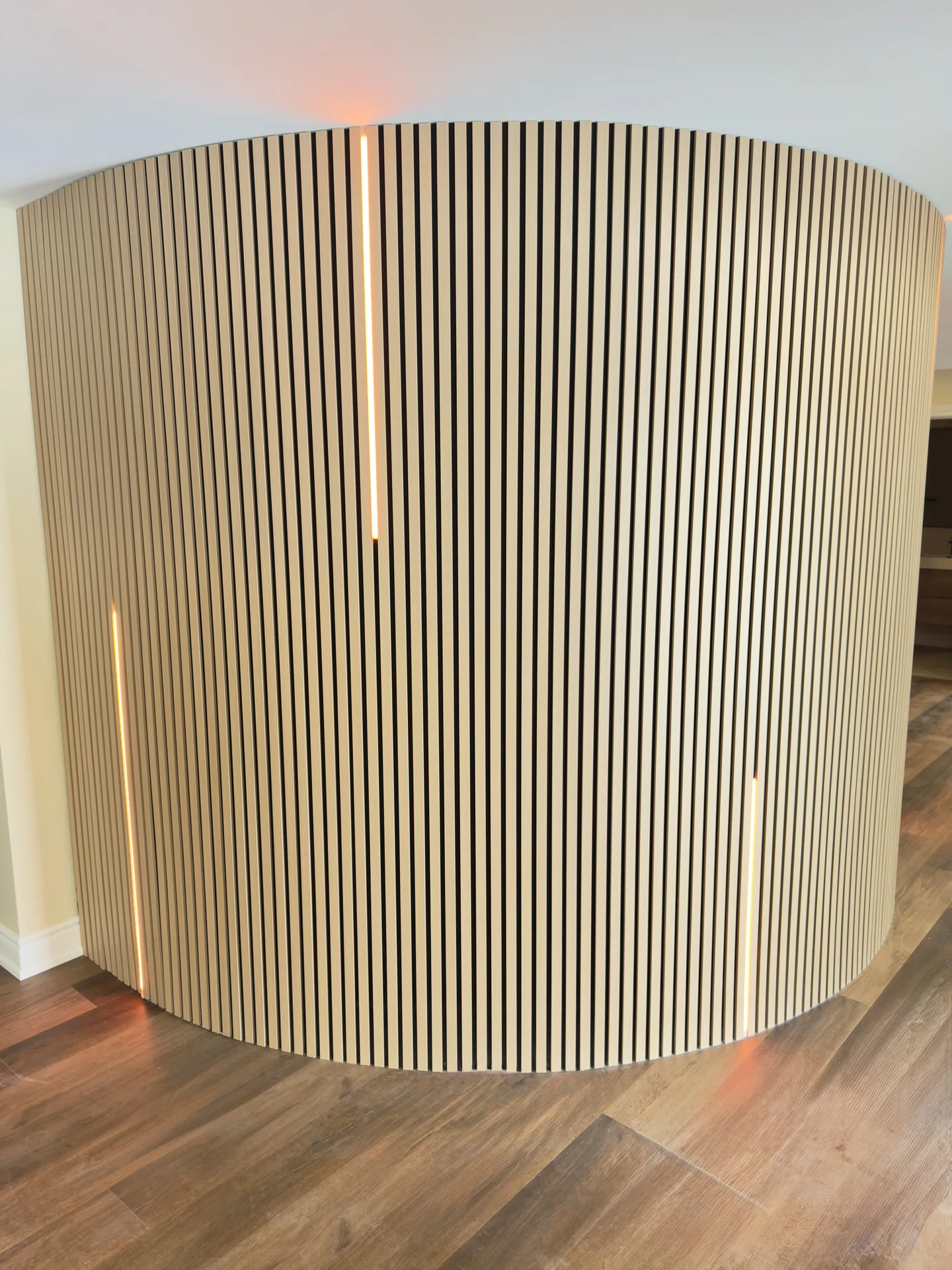 Structural work in Woodbridge — curved white oak slat feature wall with LED accents in a finished basement