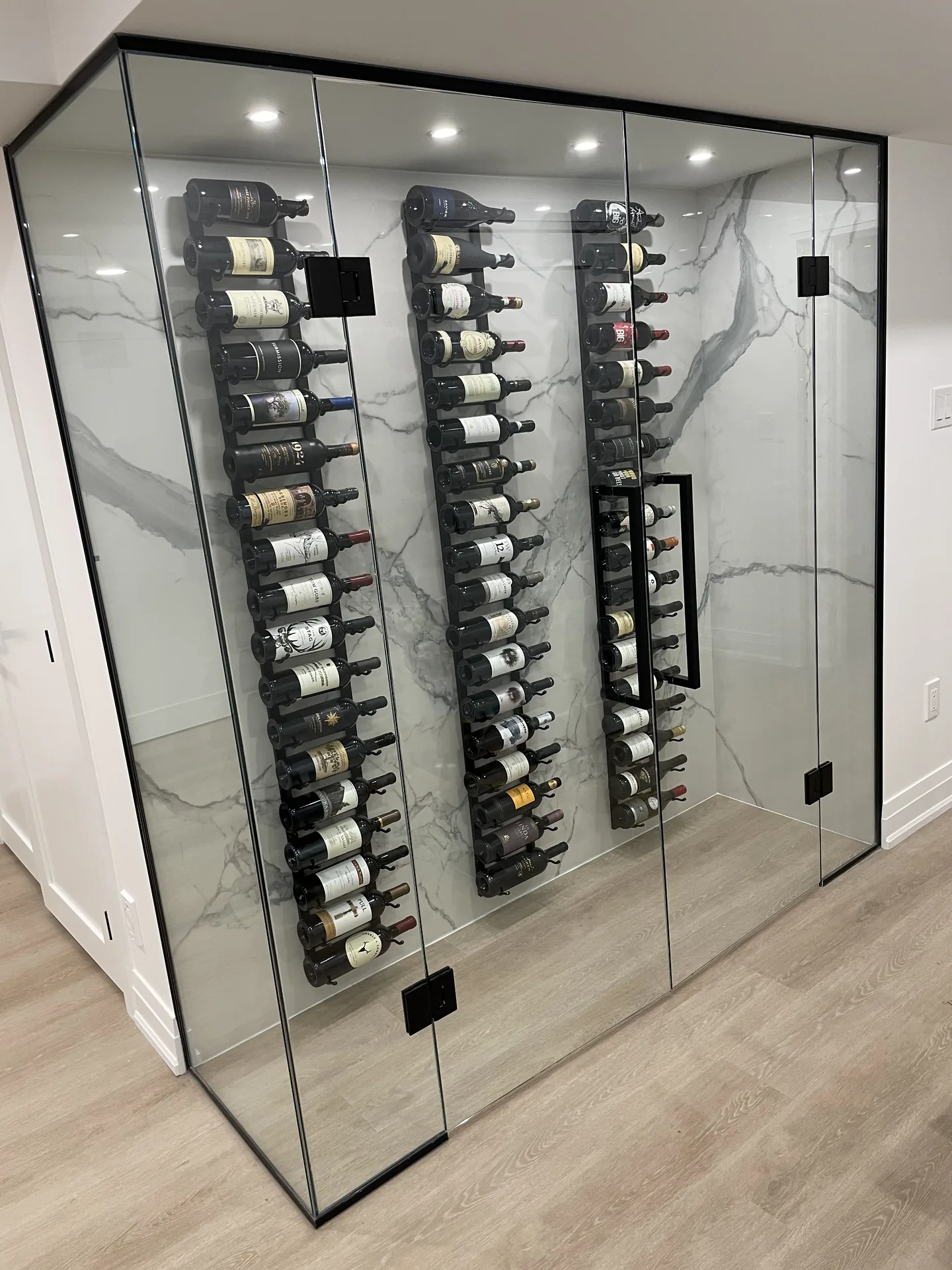 Home renovations in King City — glass wine display with marble backdrop in a finished basement