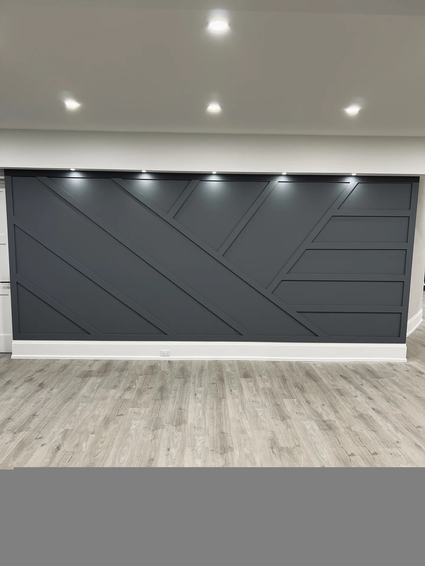 Structural work in Richmond Hill — grey geometric panel feature wall in a finished basement