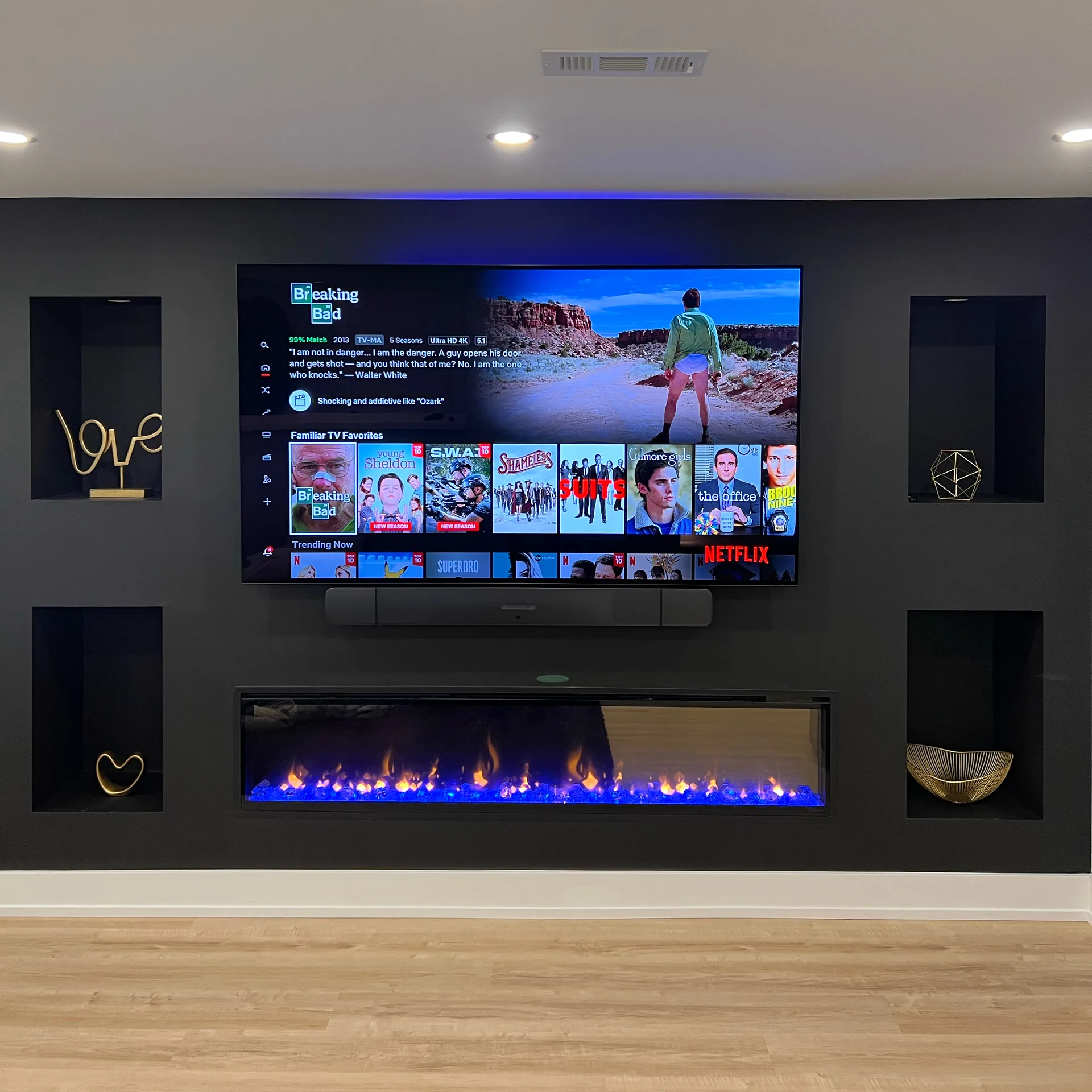 Basement finishing in Mississauga — dark basement media wall with linear fireplace and lit niches