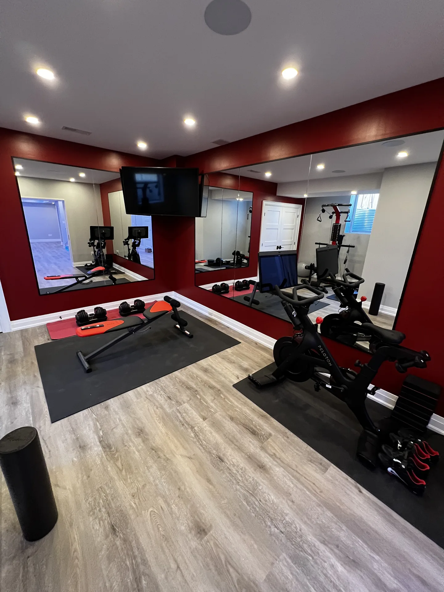 Structural work in Whitchurch-Stouffville — basement home gym with red accent wall, mirrors and equipment