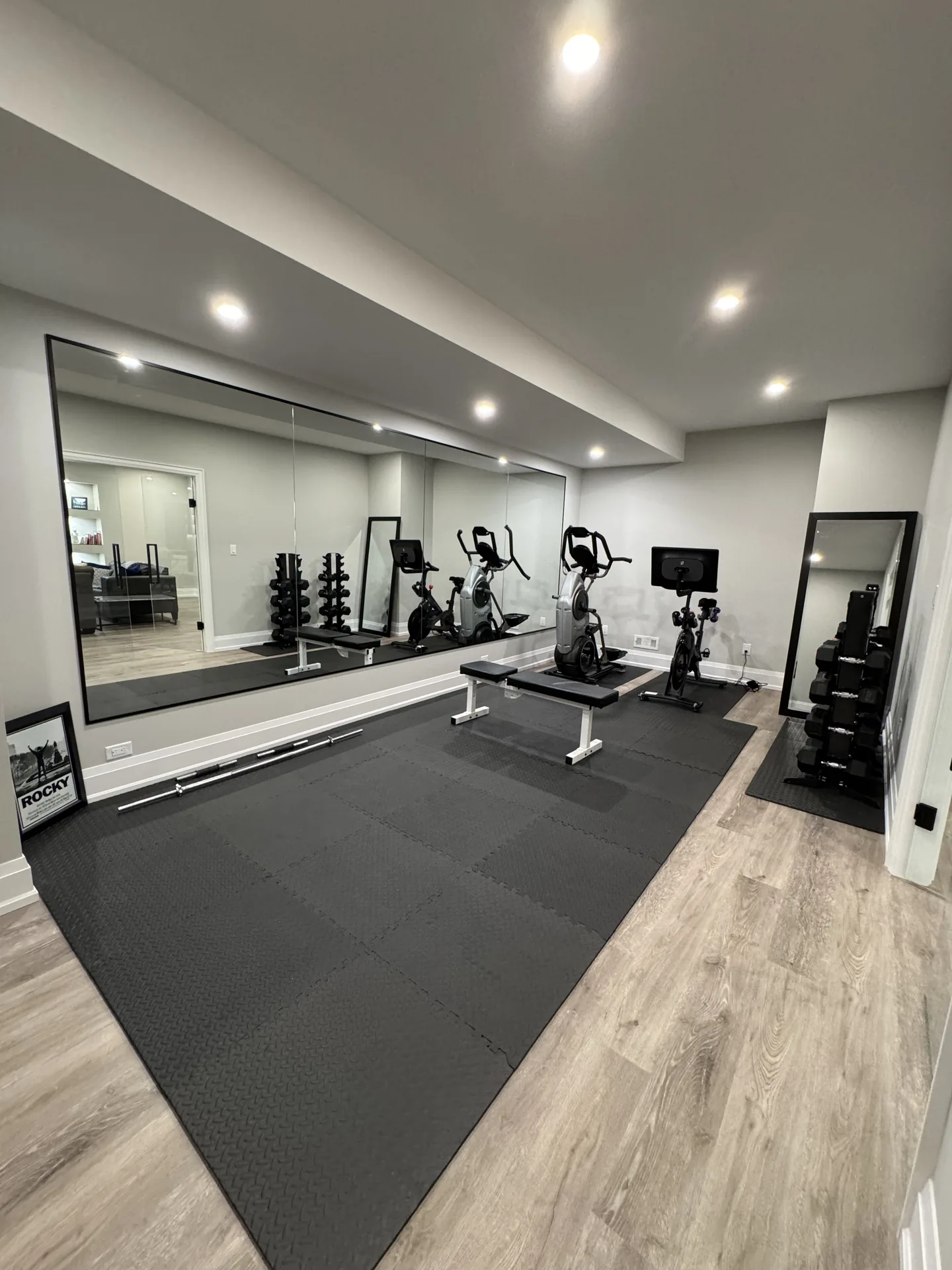 Structural work in King City — basement home gym with full mirror wall and training equipment