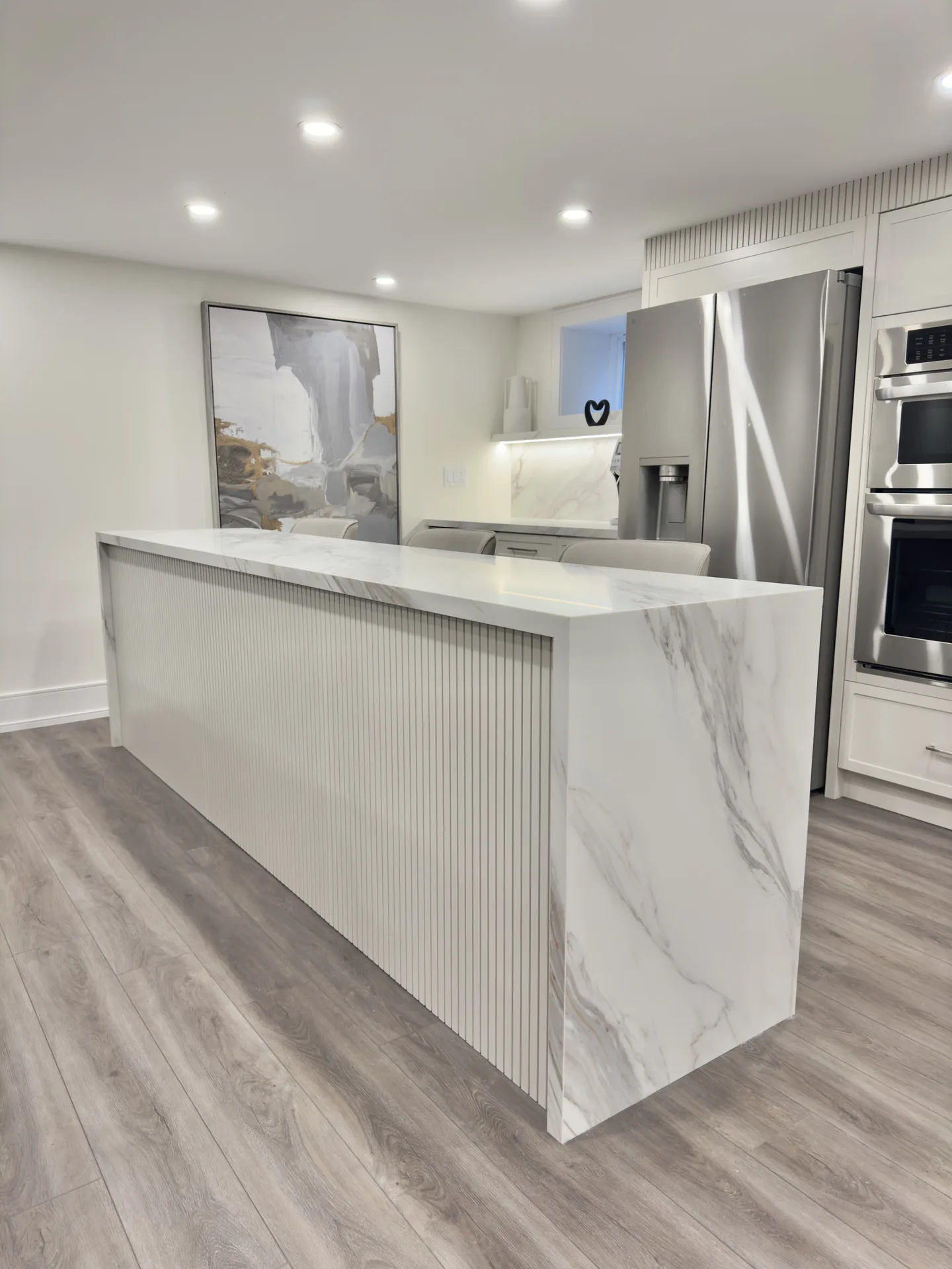 Home renovations in Bradford — basement kitchen with fluted marble waterfall island
