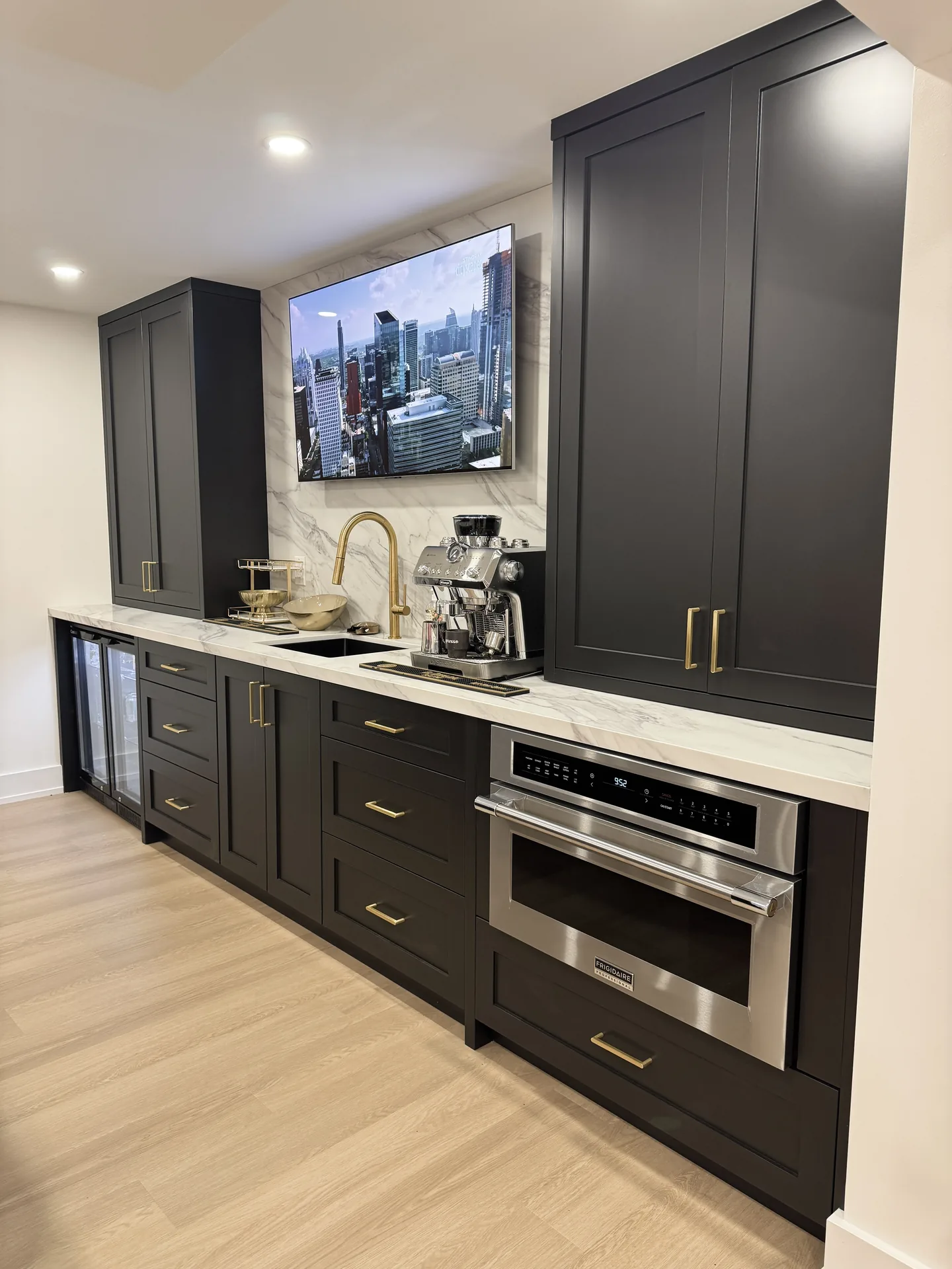 Home renovations in Caledon — basement kitchenette with dark cabinets, TV and built-in appliances
