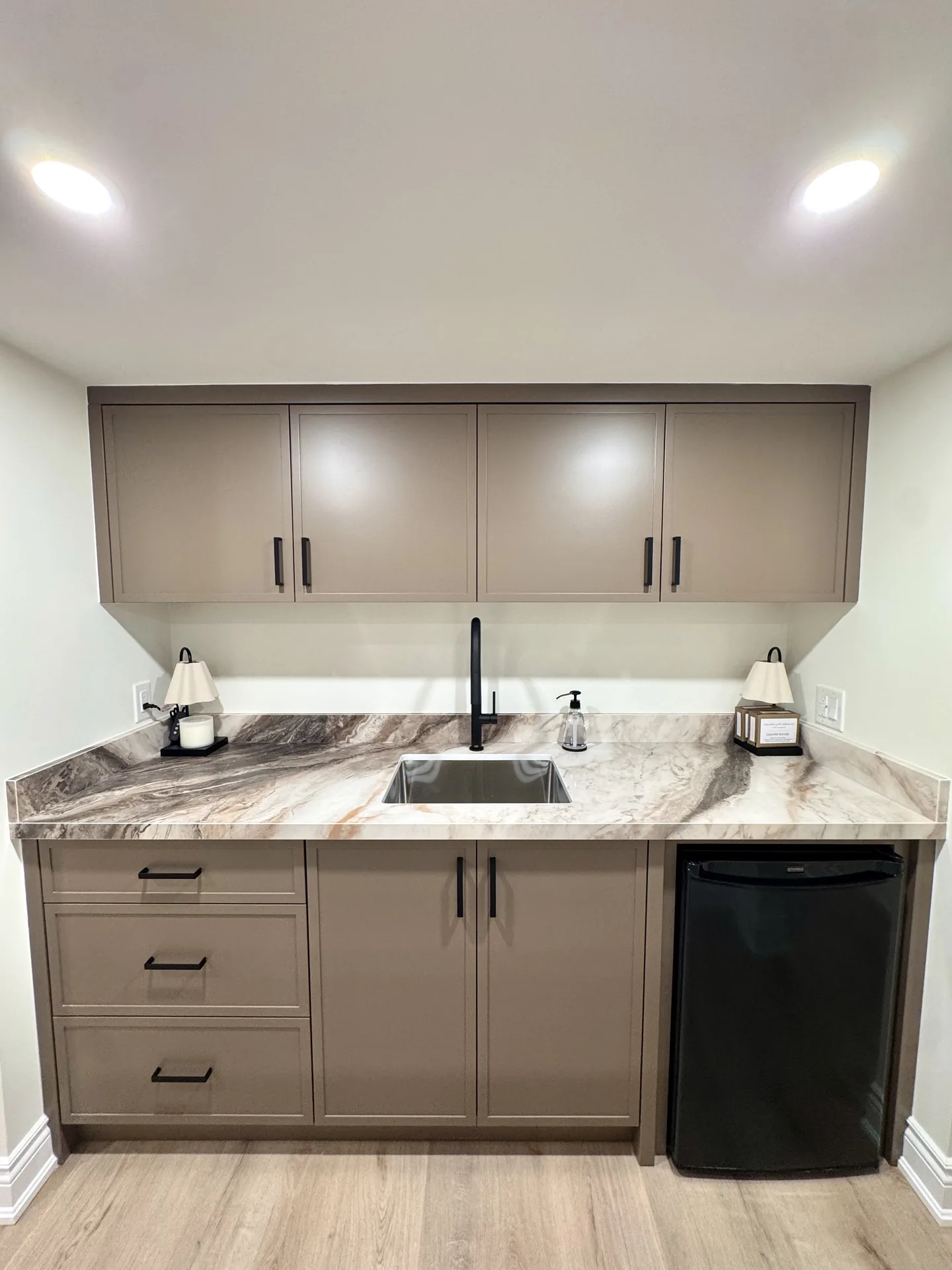 Home renovations in Burlington — basement kitchenette with two-tone cabinets and stone counters