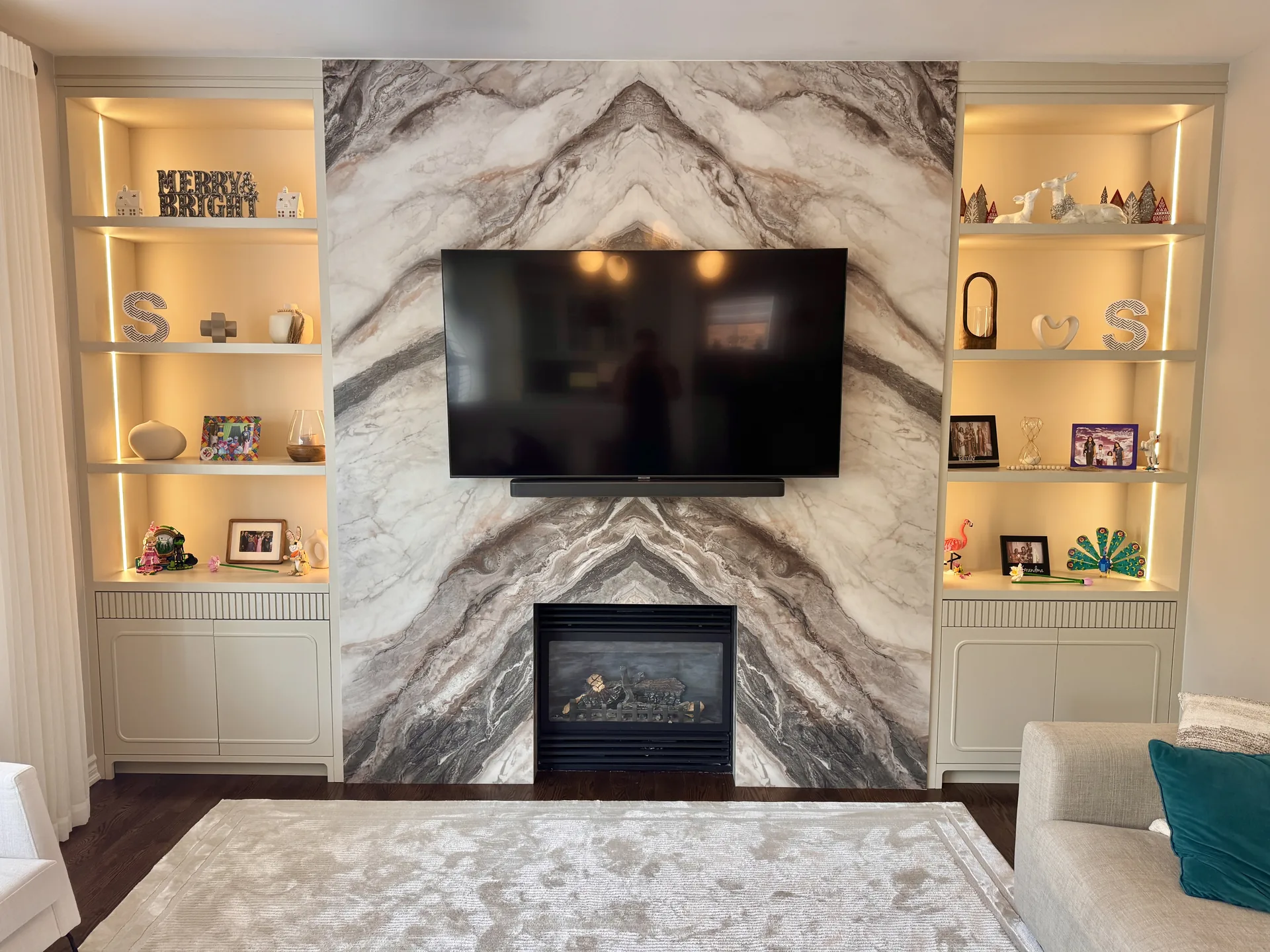 Basement finishing in Aurora — marble TV and fireplace wall with LED shelves in a finished basement