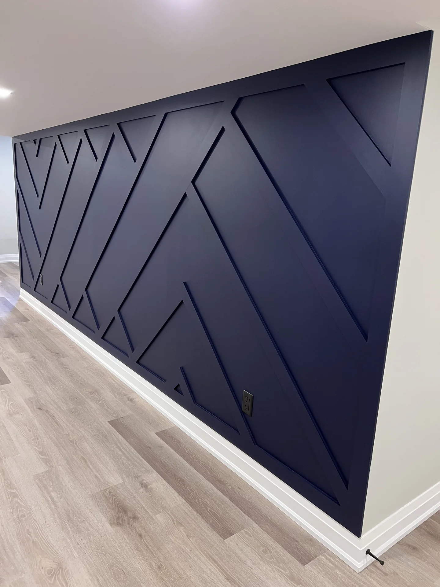 Structural work in East Gwillimbury — navy chevron feature wall built by Desire Basements