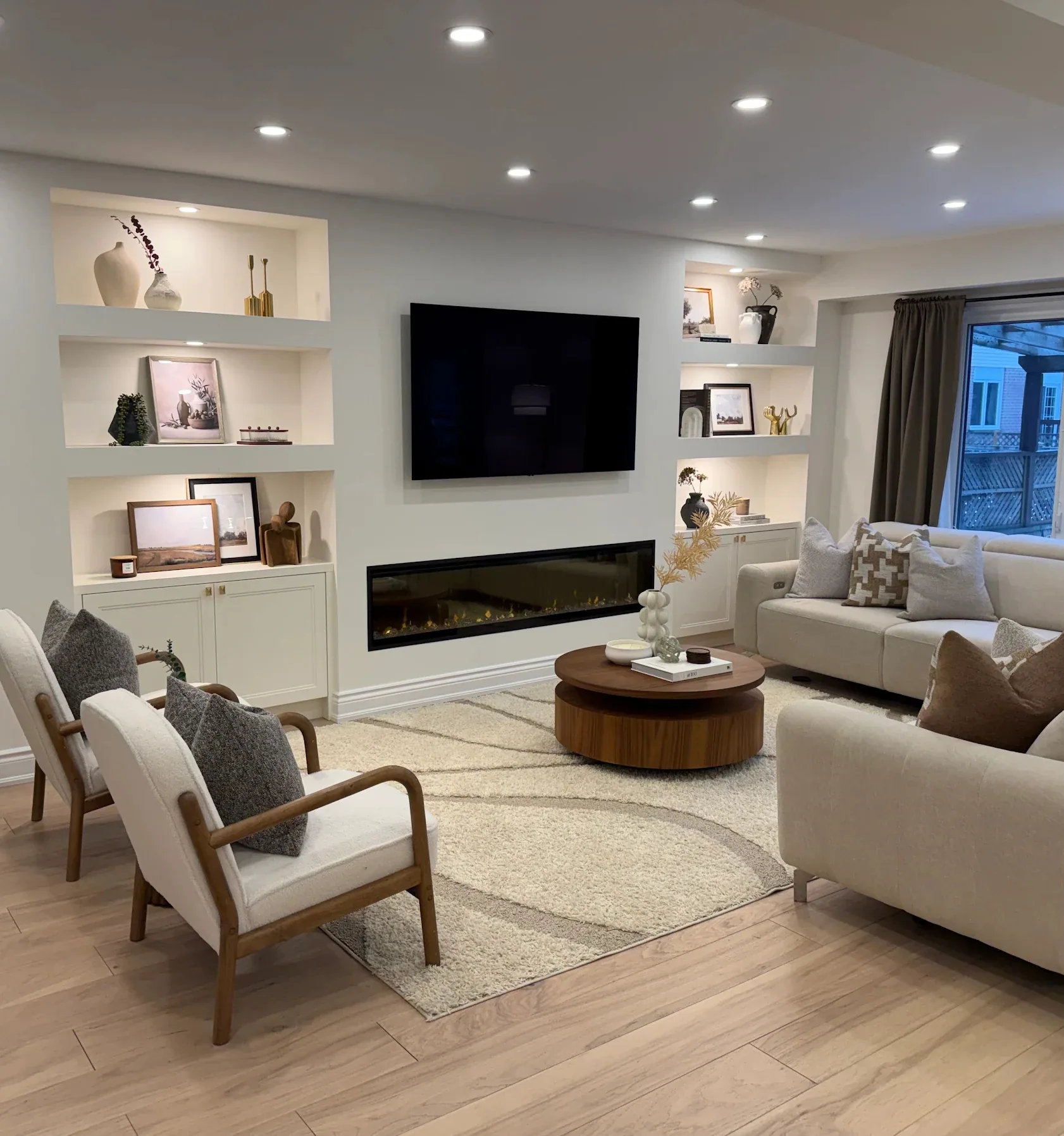 Basement media wall with armchairs and linear fireplace — basement renovation in Whitchurch-Stouffville by Desire Basements