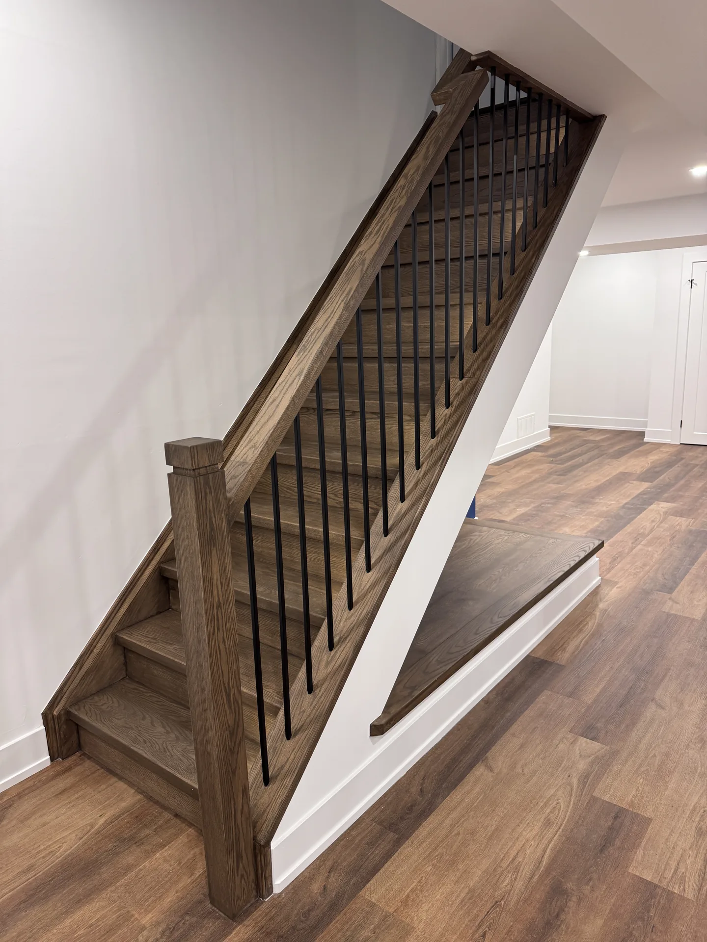 Structural work in Innisfil — oak basement staircase with black metal spindles
