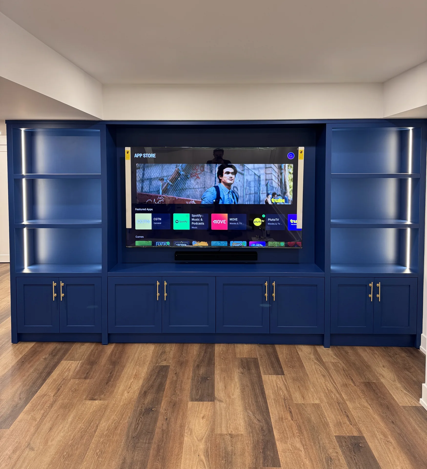 Navy media wall with LED built-ins — basement renovation in Bradford by Desire Basements