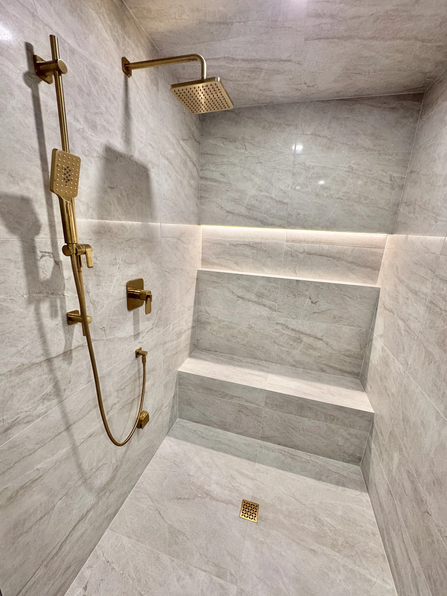 Structural work in Milton — marble spa shower with gold fixtures in a basement bathroom