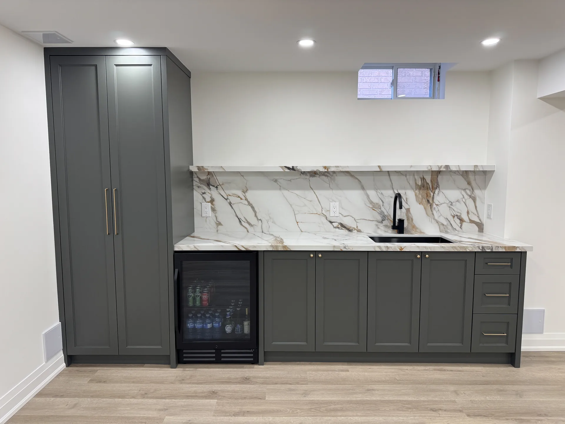 Home renovations in Oshawa — basement wet bar with grey cabinets and marble backsplash