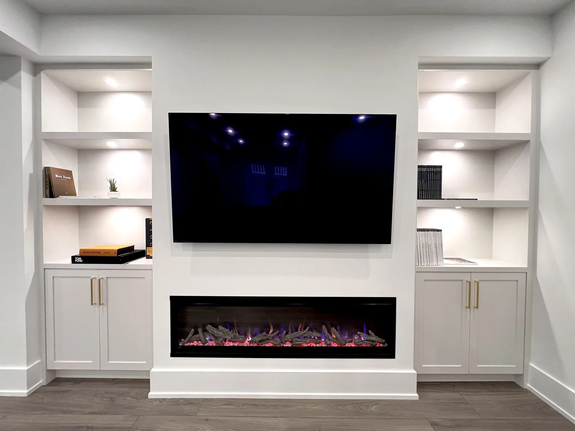 White basement media wall with fireplace and built-ins — basement renovation in Pickering by Desire Basements