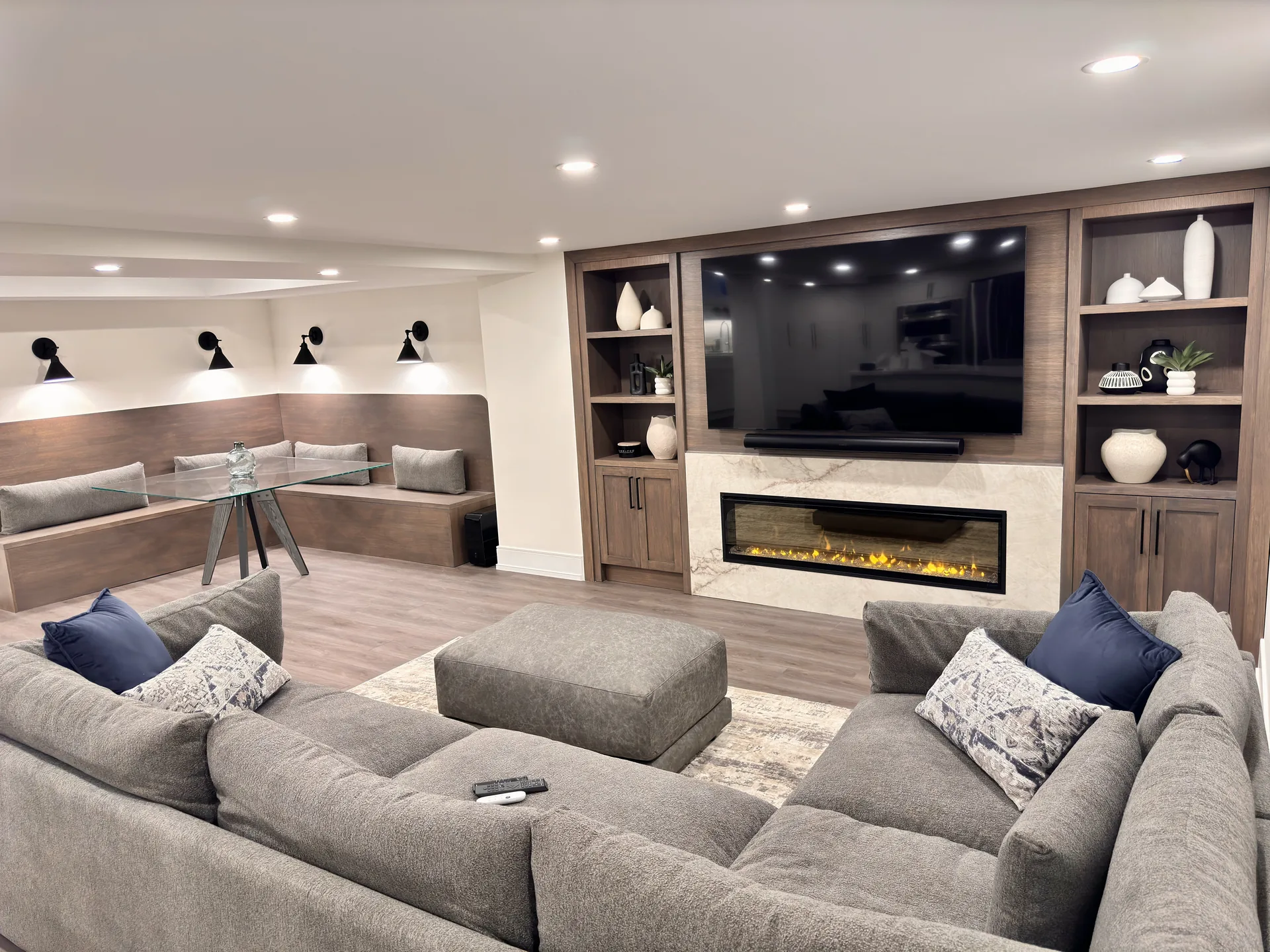 Finished basement media wall with built-ins, fireplace and sectional — basement renovation in Clarington by Desire Basements