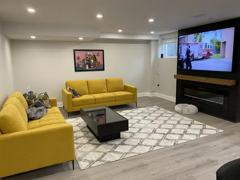 finished basement living room yellow sofas media wall