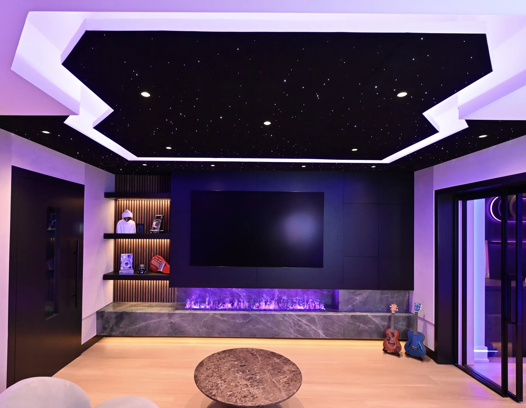Lounge with fibre-optic star ceiling, black media wall and linear fireplace at Sickick Studio
