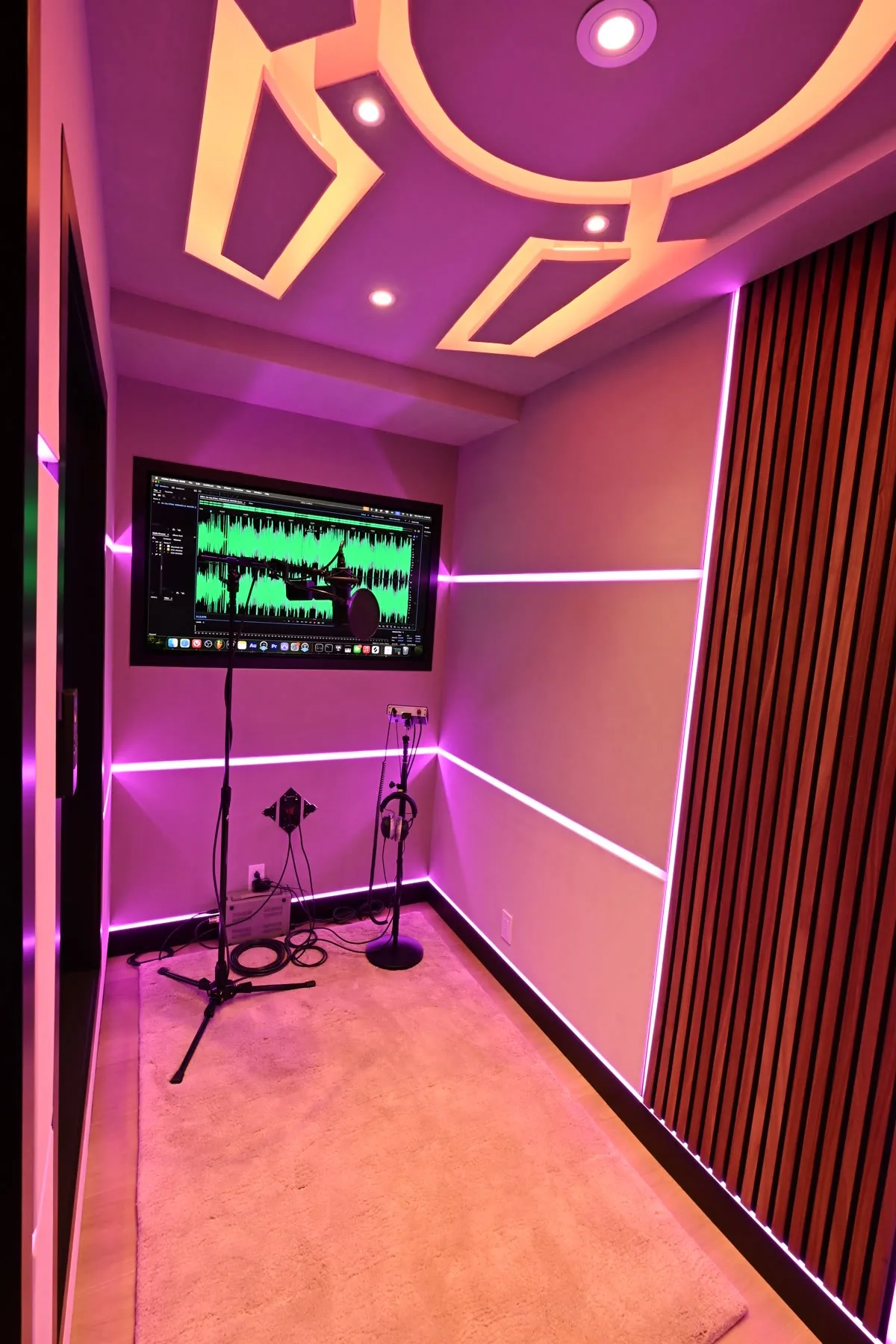 Inside the vocal booth at Sickick Studio: LED-lined walls, walnut slats, a lit ceiling panel and the monitor for the take
