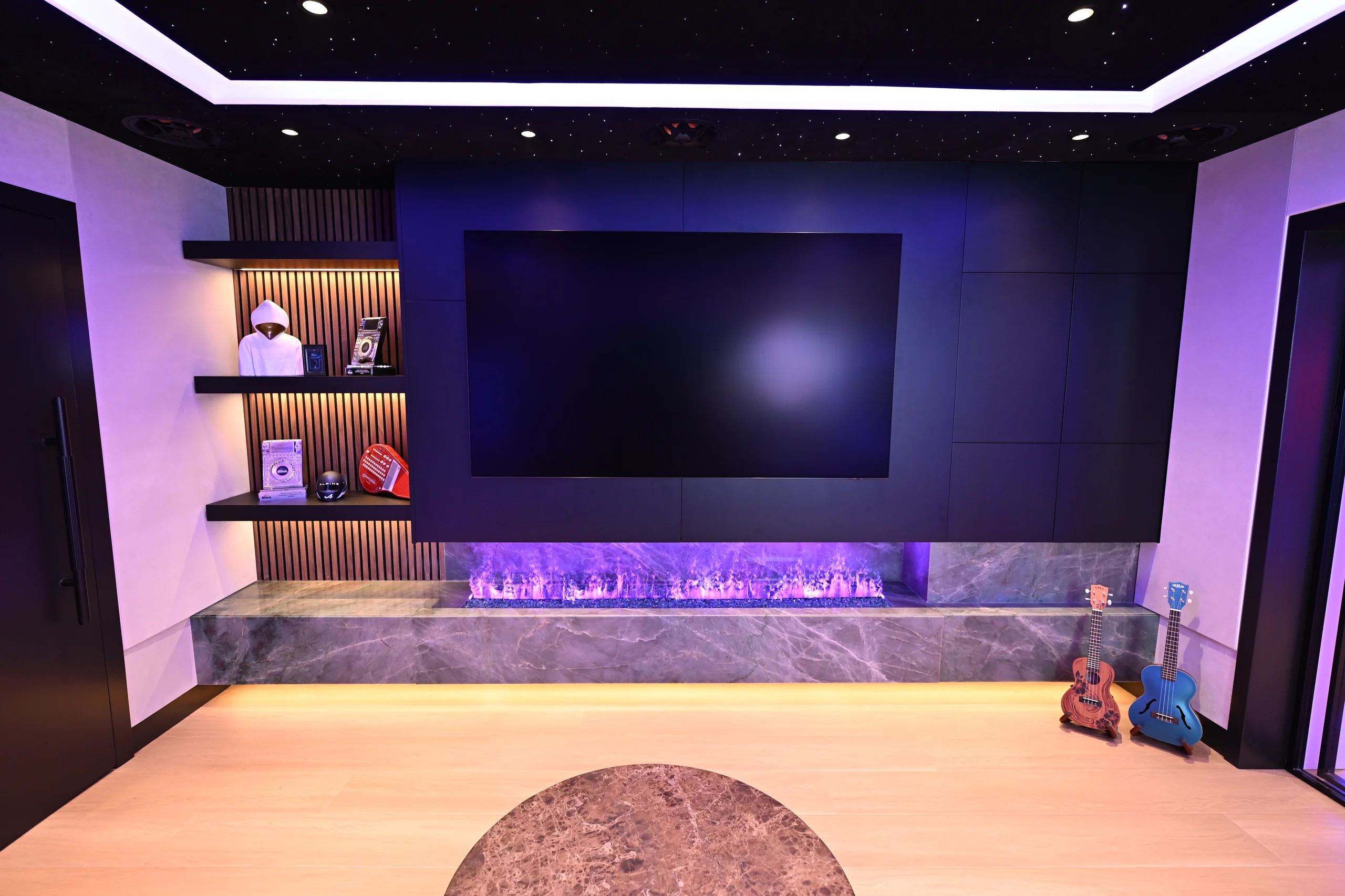 Lounge with a fibre-optic star ceiling, media wall and linear fireplace in a Toronto luxury basement
