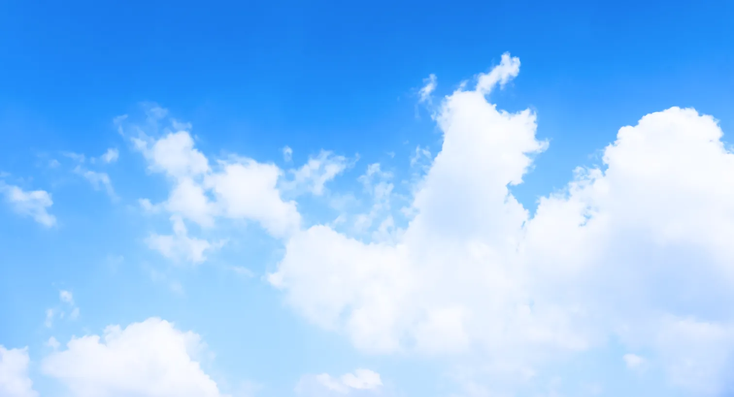 view of a beautiful bright blue sky with fluffy white clouds at the bottom